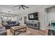 Spacious living room features hardwood floors, a ceiling fan, and a comfortable couch, perfect for relaxation and entertainment at 19437 Ship Wheel Way, Land O Lakes, FL 34638