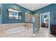Elegant bathroom with a soaking tub, glass-enclosed shower, and stylish blue walls at 208 W Amelia Ave # 1, Tampa, FL 33602