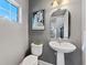 A half bath with a pedestal sink, white toilet and gray walls with modern art at 208 W Amelia Ave # 1, Tampa, FL 33602