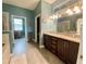 A bathroom featuring a double vanity with a granite countertop, tile floor, and doorway to an office at 208 W Amelia Ave # 1, Tampa, FL 33602
