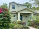 Charming home with a covered porch, blue door, and vibrant flowers in the garden at 208 W Amelia Ave # 1, Tampa, FL 33602