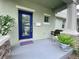 Inviting front porch with a blue door, swing, and potted plants for relaxing outdoors at 208 W Amelia Ave # 1, Tampa, FL 33602