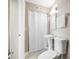 Cozy bathroom with pedestal sink, toilet, vanity mirror, and a folding privacy screen at 217 Emerald Ln, Largo, FL 33771