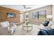 Bright living room featuring a rustic wood wall, modern ceiling fan, and stylish decor and furniture at 217 Emerald Ln, Largo, FL 33771