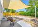 Shaded patio with two chairs, covered by a tan shade structure and surrounded by a wooden fence at 217 Emerald Ln, Largo, FL 33771