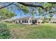 View of the spacious backyard and white exterior of the house at 2222 Mayfield Palms Ln # 322, Sun City Center, FL 33573