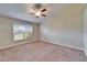 Bedroom featuring neutral carpet, ceiling fan, and a large window for natural light at 2222 Mayfield Palms Ln # 322, Sun City Center, FL 33573