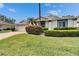 Home with vibrant green lawn, colorful bushes, brick driveway, and charming architectural details at 2222 Mayfield Palms Ln # 322, Sun City Center, FL 33573