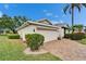 Home exterior with a brick driveway and well manicured landscaping at 2222 Mayfield Palms Ln # 322, Sun City Center, FL 33573