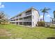 Exterior angle of the condo showing multi-level balconies and a lush green lawn for residents to enjoy at 255 Capri N Cir # 8, Treasure Island, FL 33706