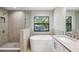 Modern bathroom featuring a soaking tub, glass enclosed shower, dual sink vanity, and a large window at 2618 15Th N Ave, St Petersburg, FL 33713