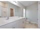 Bathroom featuring double sinks with white countertops, and a shower with white tiles at 37233 Sagemoor Dr, Zephyrhills, FL 33541