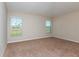 Spacious bedroom featuring neutral walls, plush carpeting, and two windows offering natural light at 37233 Sagemoor Dr, Zephyrhills, FL 33541