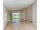 Bright living room featuring wood flooring, neutral walls, and sliding glass door to the backyard at 37233 Sagemoor Dr, Zephyrhills, FL 33541