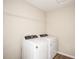 This is a well-lit laundry room featuring modern, side-by-side washer and dryer appliances at 37260 Sagemoor Dr, Zephyrhills, FL 33541