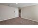 Spacious bedroom with neutral walls and carpeted floor shows adjacent laundry room at 37276 Sagemoor Dr, Zephyrhills, FL 33541