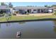 Waterfront backyard with lush landscaping and a view of a pond featuring turtles basking in the sun at 3729 Sail Dr, New Port Richey, FL 34652