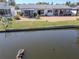 Backyard of waterfront home features gravel, grass and screened in porch at 3729 Sail Dr, New Port Richey, FL 34652