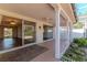 Covered outdoor patio with multiple sliding glass door entrances and a serene garden at 3729 Sail Dr, New Port Richey, FL 34652