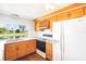 Kitchen with wood cabinetry, white countertops, and appliances, plus a scenic view of the water at 3729 Sail Dr, New Port Richey, FL 34652