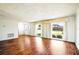 A bright living room featuring wood floors, white walls, and large windows that let in ample natural light at 3729 Sail Dr, New Port Richey, FL 34652