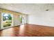 Bright living room features wood floors, white walls with wainscotting, and large windows with backyard views at 3729 Sail Dr, New Port Richey, FL 34652