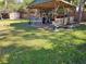 Spacious backyard featuring a covered gazebo and lush green lawn perfect for entertaining and relaxation at 402 8Th Sw St, Ruskin, FL 33570