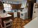 Well-lit kitchen featuring wood cabinets, white appliances and colorful wall decorations at 402 8Th Sw St, Ruskin, FL 33570