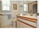 Bright bathroom with a white toilet, vanity with ample counter space, and natural light at 4078 Salem Square Pkwy, Palm Harbor, FL 34685
