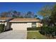 Charming single-story home with a two-car garage, well-manicured lawn, and mature landscaping at 4078 Salem Square Pkwy, Palm Harbor, FL 34685