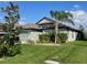 Charming one-story home with landscaped front yard, lush green grass, and elegant palm tree at 6024 162Nd E Ave, Parrish, FL 34219