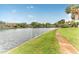 Scenic waterfront property featuring a lush lawn and sidewalk bordering calm water at 6315 Newtown Cir # 15B3, Tampa, FL 33615