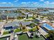 Detailed aerial view of waterfront property featuring private docks, lush landscaping, swimming pool, and serene water views at 6410 3Rd Palm Pt, St Pete Beach, FL 33706