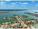 Expansive aerial perspective showcasing waterfront homes, boat docks, and lush greenery with a beautiful bay backdrop at 6410 3Rd Palm Pt, St Pete Beach, FL 33706