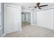 Bedroom featuring stylish ceiling fan, neutral wall color, and three closet doors at 6410 3Rd Palm Pt, St Pete Beach, FL 33706