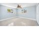 This light-filled bedroom features tile flooring, modern ceiling fan, and large windows at 6410 3Rd Palm Pt, St Pete Beach, FL 33706