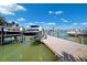 A boat is docked in a tranquil waterfront setting, with lush greenery and clear skies at 6410 3Rd Palm Pt, St Pete Beach, FL 33706