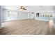 Open-concept living room features built-in cabinets, modern light fixtures, and wood-look flooring at 6410 3Rd Palm Pt, St Pete Beach, FL 33706