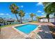 Private pool with brick surround complemented by mature palm trees and waterfront views at 6410 3Rd Palm Pt, St Pete Beach, FL 33706