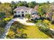 Aerial view of a grand two-story home with circular driveway and lush green lawn with mature trees at 6413 Maclaurin Dr, Tampa, FL 33647