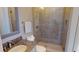 Elegant bathroom with a granite countertop, a glass-enclosed shower and neutral colored tile at 6413 Maclaurin Dr, Tampa, FL 33647