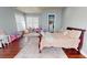 Bright bedroom featuring an ensuite and closet space, a large window and a plush rug on the dark wood floor at 6413 Maclaurin Dr, Tampa, FL 33647