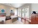 Bright bedroom with hardwood floors, ceiling fan, neutral walls, and sliding glass door at 6413 Maclaurin Dr, Tampa, FL 33647