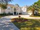 Elegant white home featuring a circular driveway and lush, landscaped front yard at 6413 Maclaurin Dr, Tampa, FL 33647