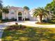 Elegant two-story white home featuring a circular driveway and lush, landscaped front yard at 6413 Maclaurin Dr, Tampa, FL 33647