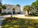 Elegant two-story white home featuring a circular driveway and lush, landscaped front yard at 6413 Maclaurin Dr, Tampa, FL 33647