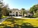 Stunning two-story home with a circular driveway, manicured lawn, and mature trees providing shade at 6413 Maclaurin Dr, Tampa, FL 33647