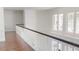 Bright hallway featuring hardwood floors, white trim, and natural light from nearby windows at 6413 Maclaurin Dr, Tampa, FL 33647