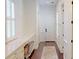 Hallway with built-in desk, drawers, and a chair, with wood-look floors and bright, white walls at 6413 Maclaurin Dr, Tampa, FL 33647