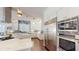 Gourmet kitchen featuring white cabinetry, stainless steel appliances, and modern lighting fixtures at 6413 Maclaurin Dr, Tampa, FL 33647